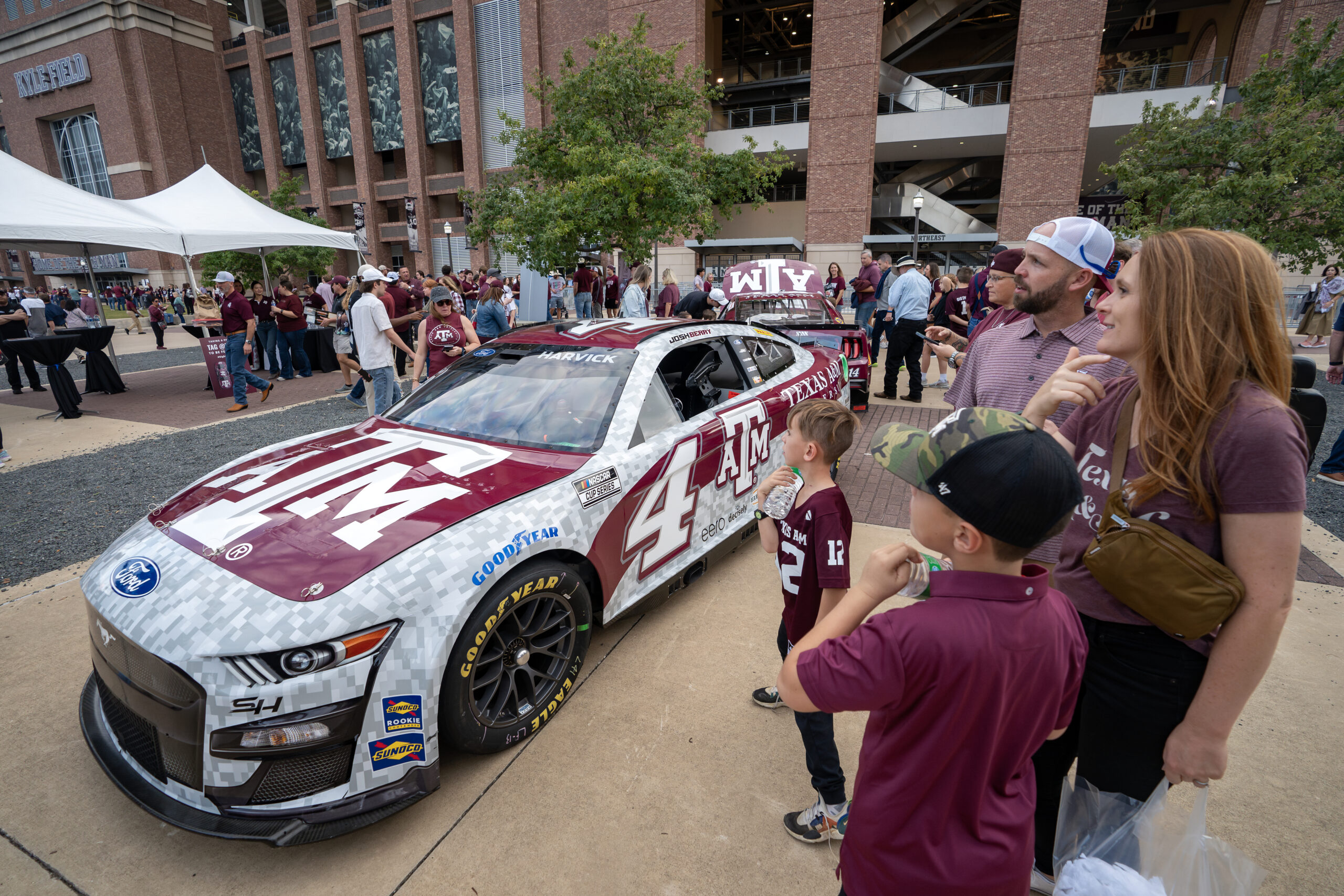 Aggie Fans looking at the Texas A&M branded NASCAR vehicle