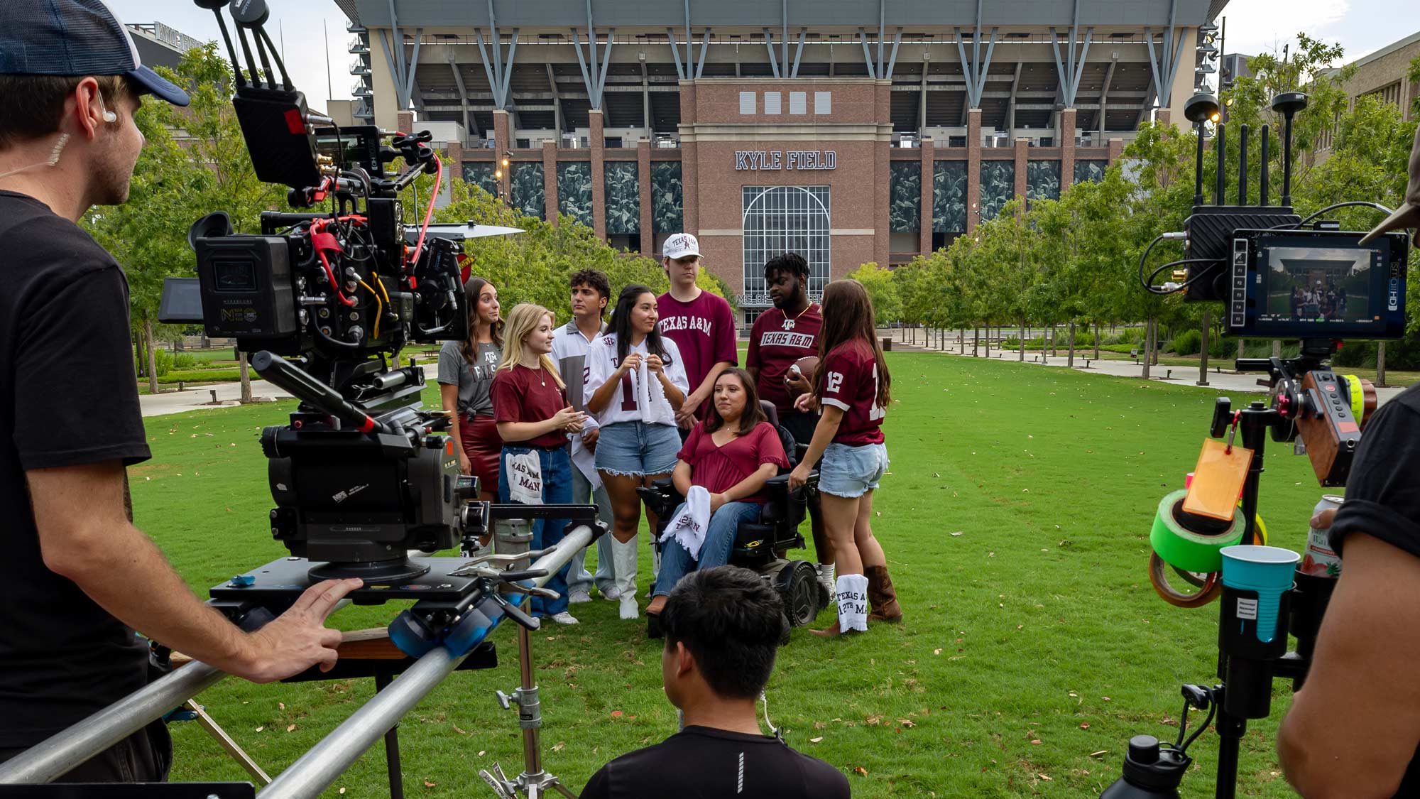 Behind the scenes of the Texas A&M commercial shoot, film cameras zoom in on a group of Aggie Students