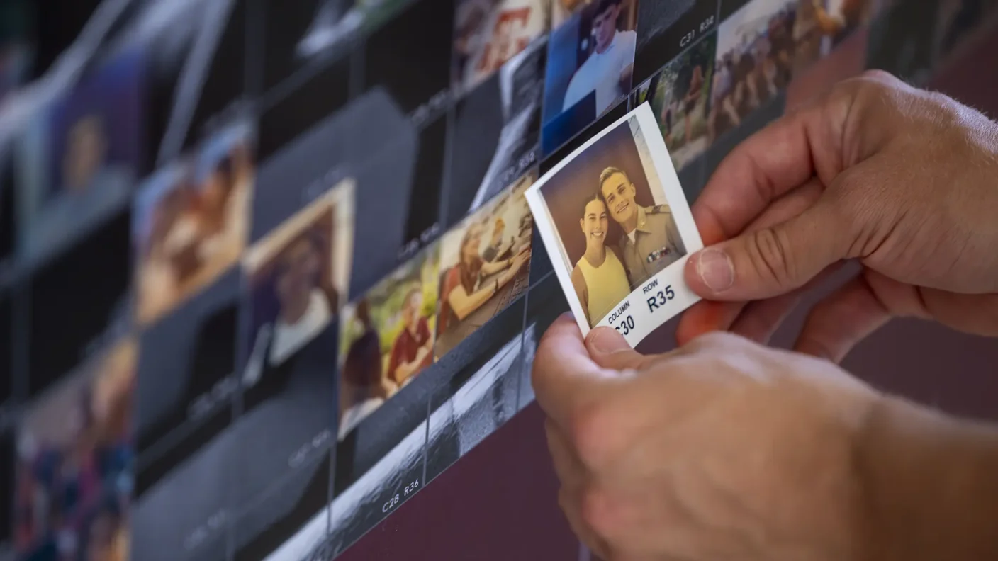 Student places photo of them and a friend onto the photo mosaic wall