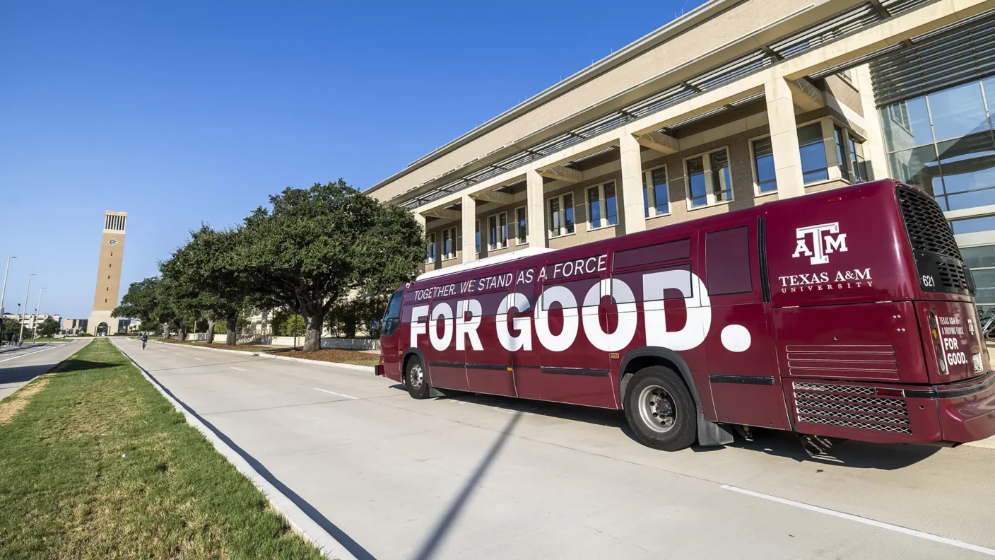 Texas A&M Aggie Spirit Bus with the "Together, we stand as a force for good" wrap drives through campus